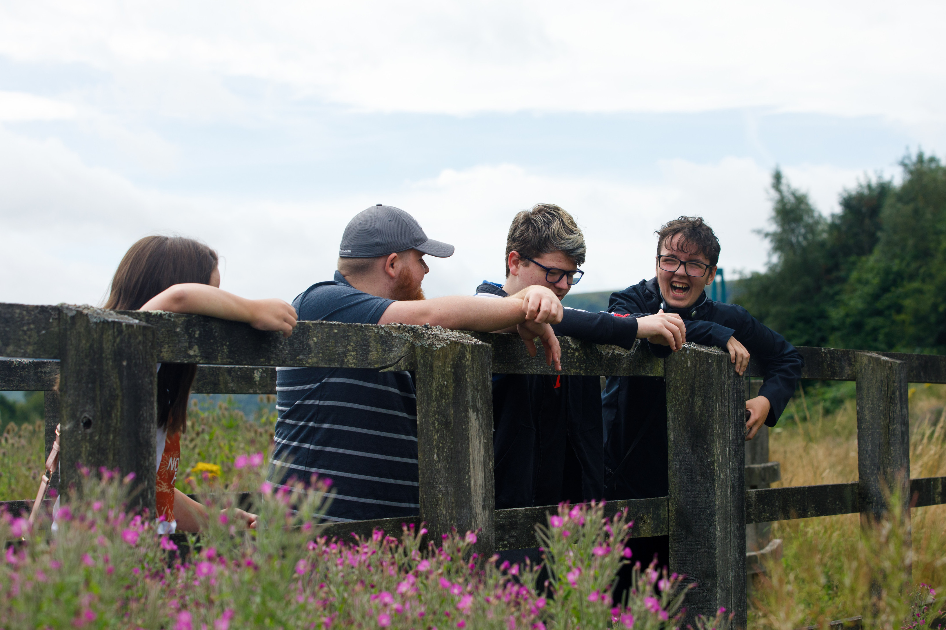 four young people Llamau support laughing together while out for a walk in the field
