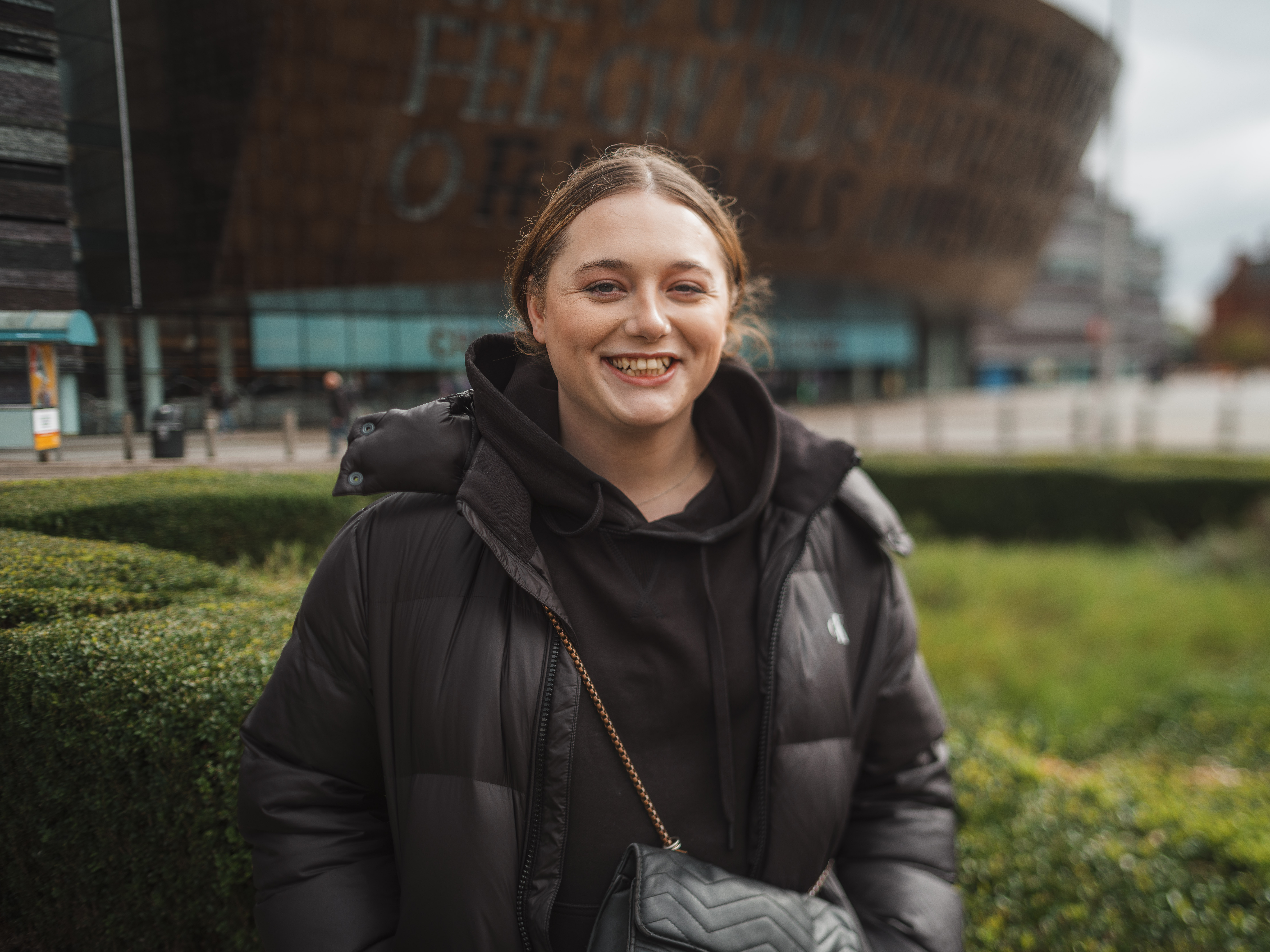Rhiannon stands outside the Wales Millennium Centre smiling